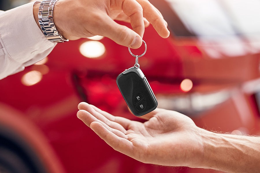 Close up of a pair of hands exchanging a car key fob